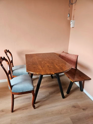 Houten eettafel met zwart metalen onderstel met zitbankje